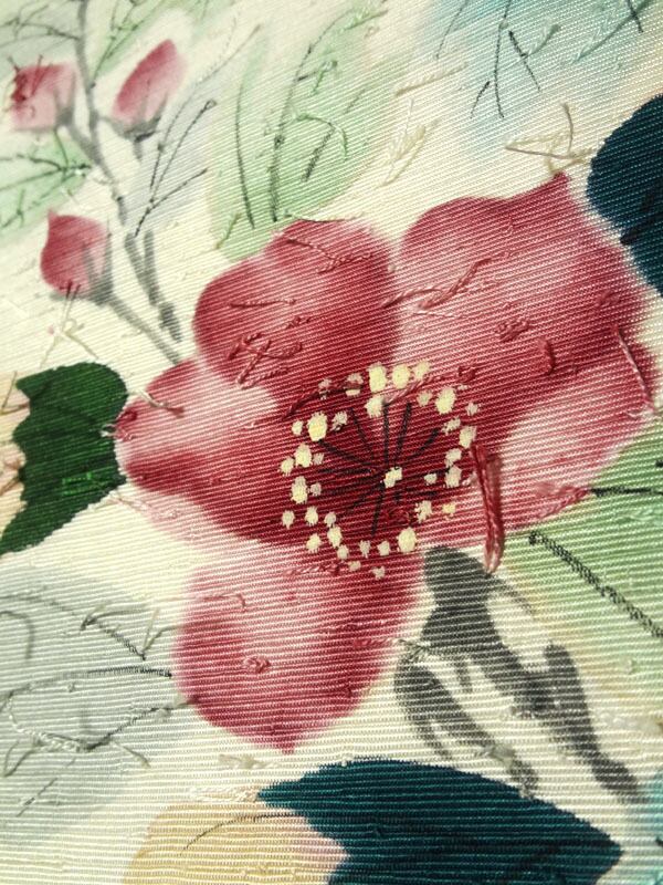 ほんのり生成り色のひげ紬に大柄の花　名古屋帯