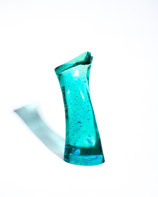 A streamlined, turquoise-blue glass object