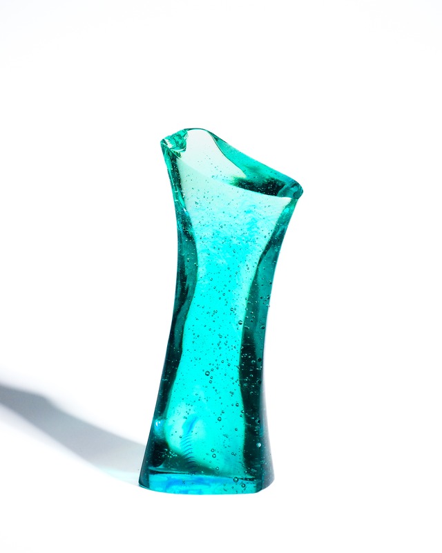 A streamlined, turquoise-blue glass object