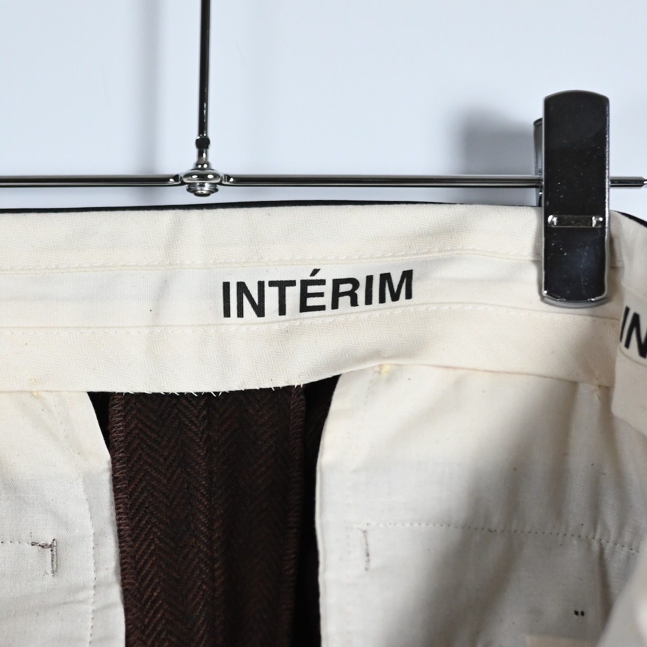 INTERIM / INDIA WOOL CLASSIC HERRINGBONE WITH LEATHER PIPING 2-TUCK STRAIGHT SLACKS