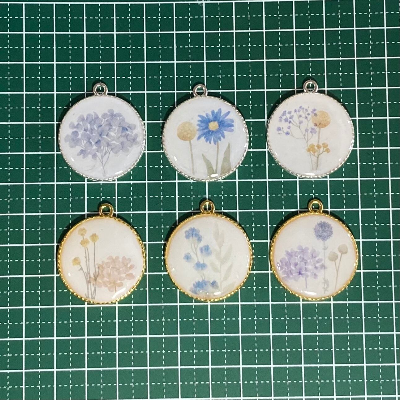 花が描かれた白くて丸いペンダントトップ シックな雰囲気のレジン