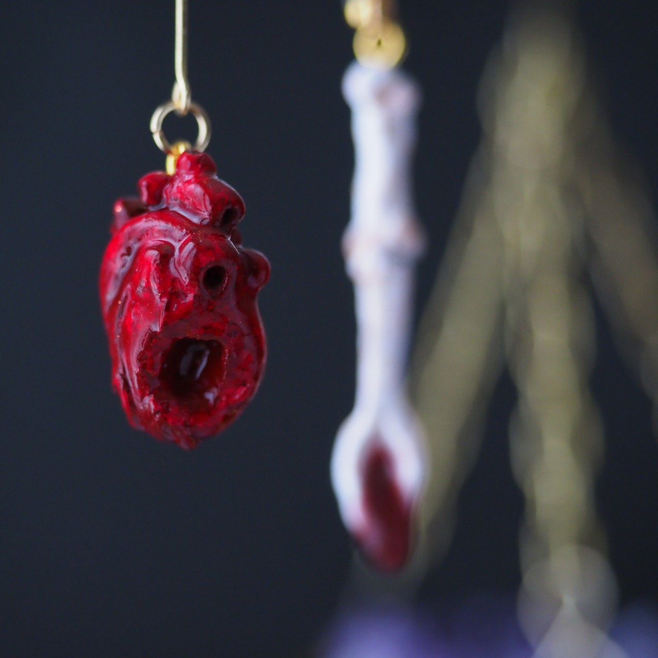 抉れた心臓と大腿骨スプーン の耳飾り