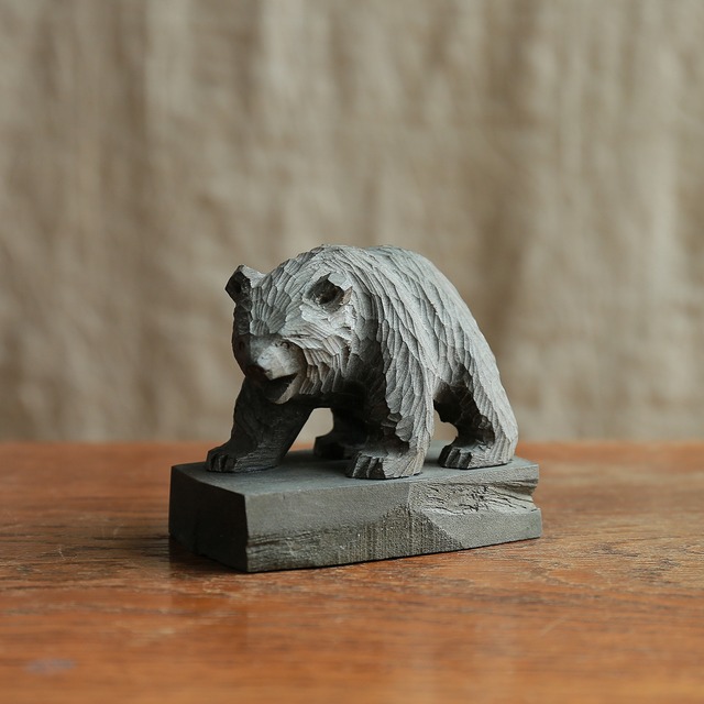 優しい顔で威嚇する、グレーのクマ