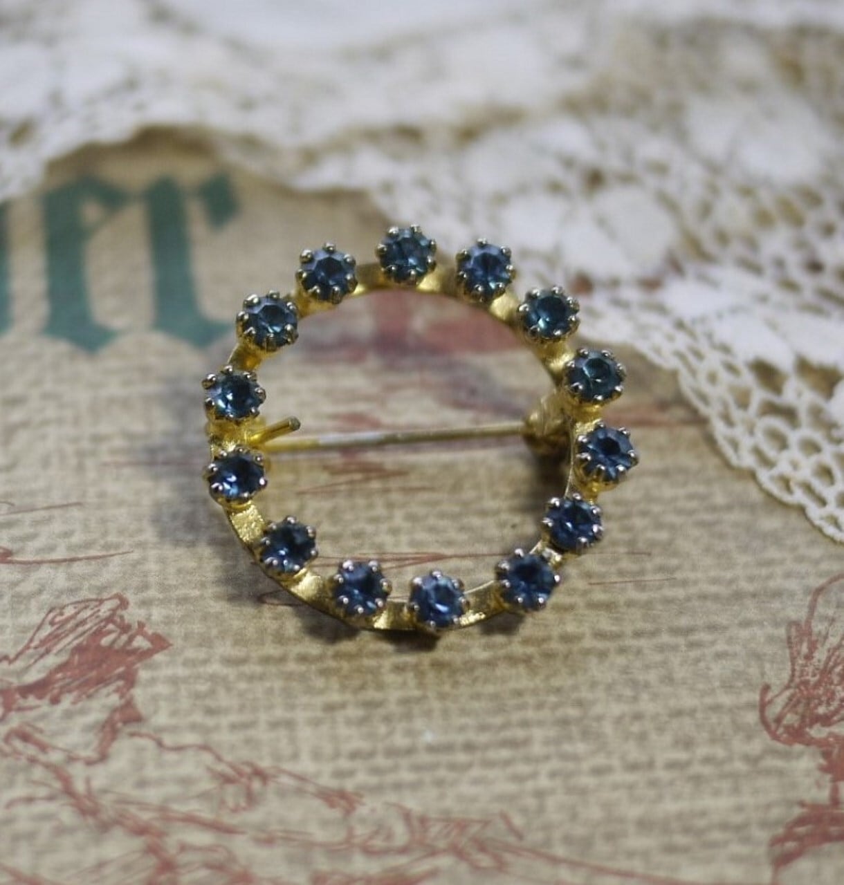 輪のブローチ 青いガラス