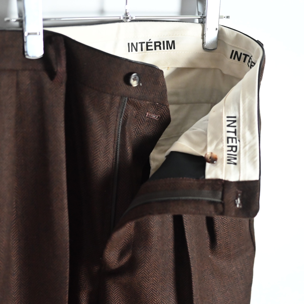INTERIM / INDIA WOOL CLASSIC HERRINGBONE WITH LEATHER PIPING 2-TUCK STRAIGHT SLACKS