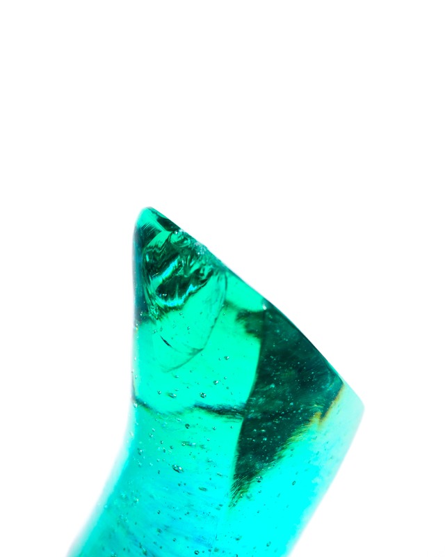 A streamlined, turquoise-blue glass object