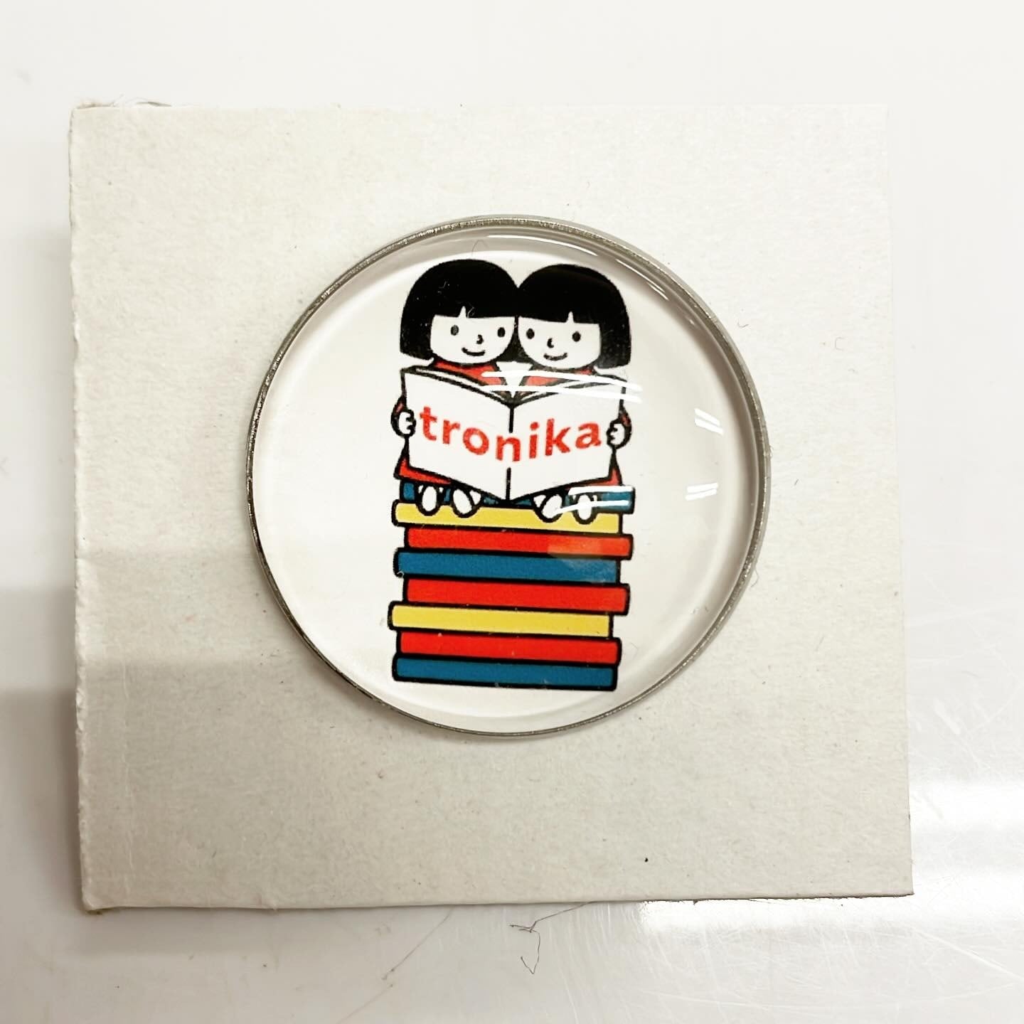 ピンバッジ「トロニカ　双子　イラスト　2人で座って本を読む」 - 画像1