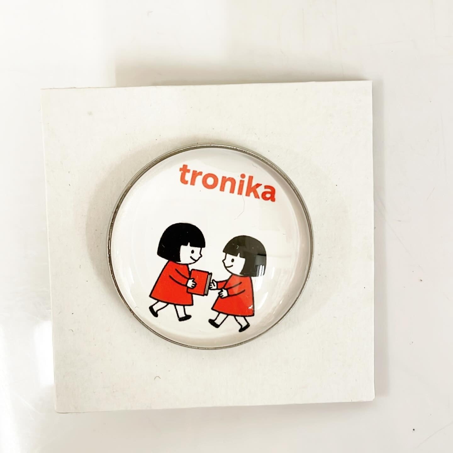 ピンバッジ「トロニカ　双子　イラスト　本を渡す」 - 画像1