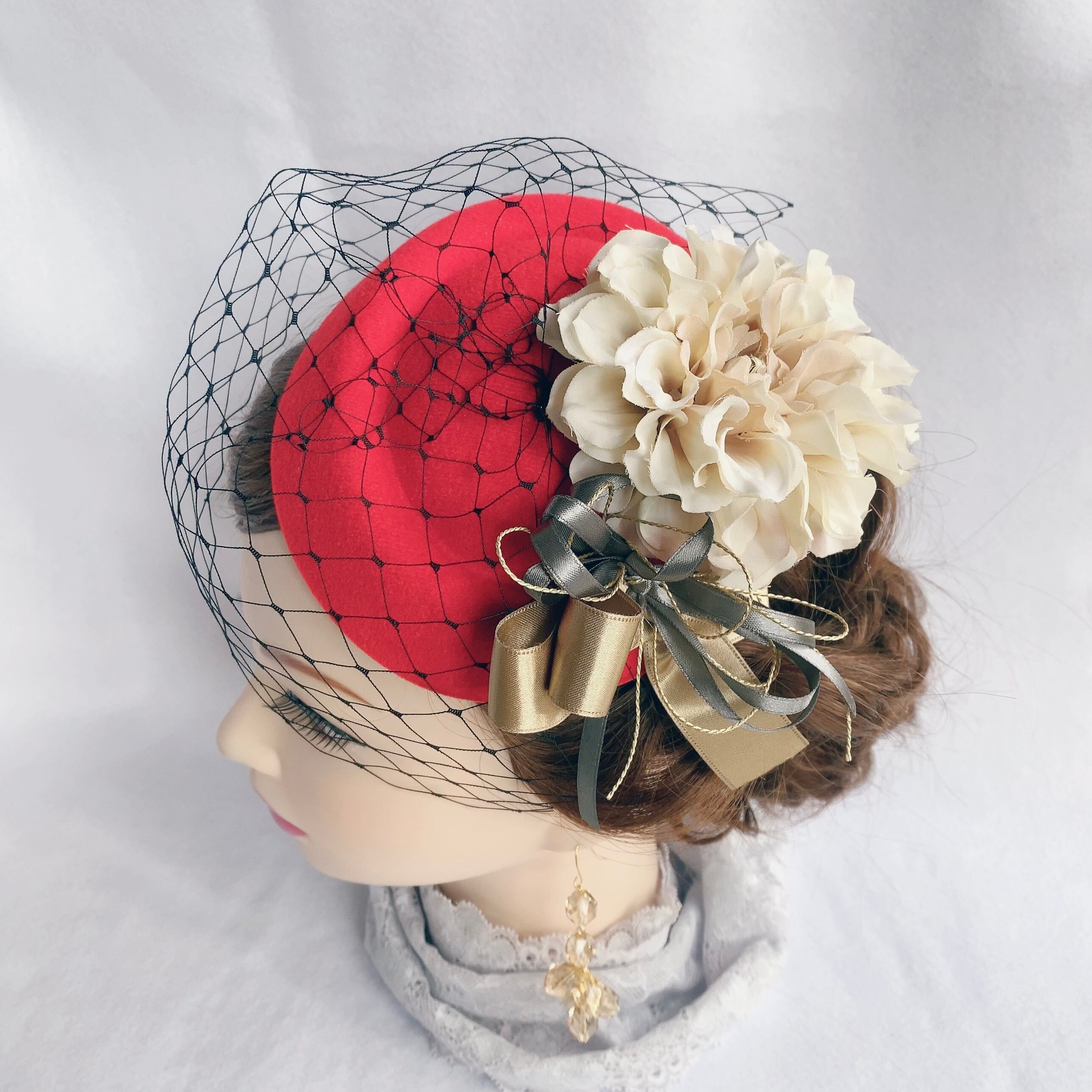 ゴールドのリボンがキラッとしている赤のトークハット