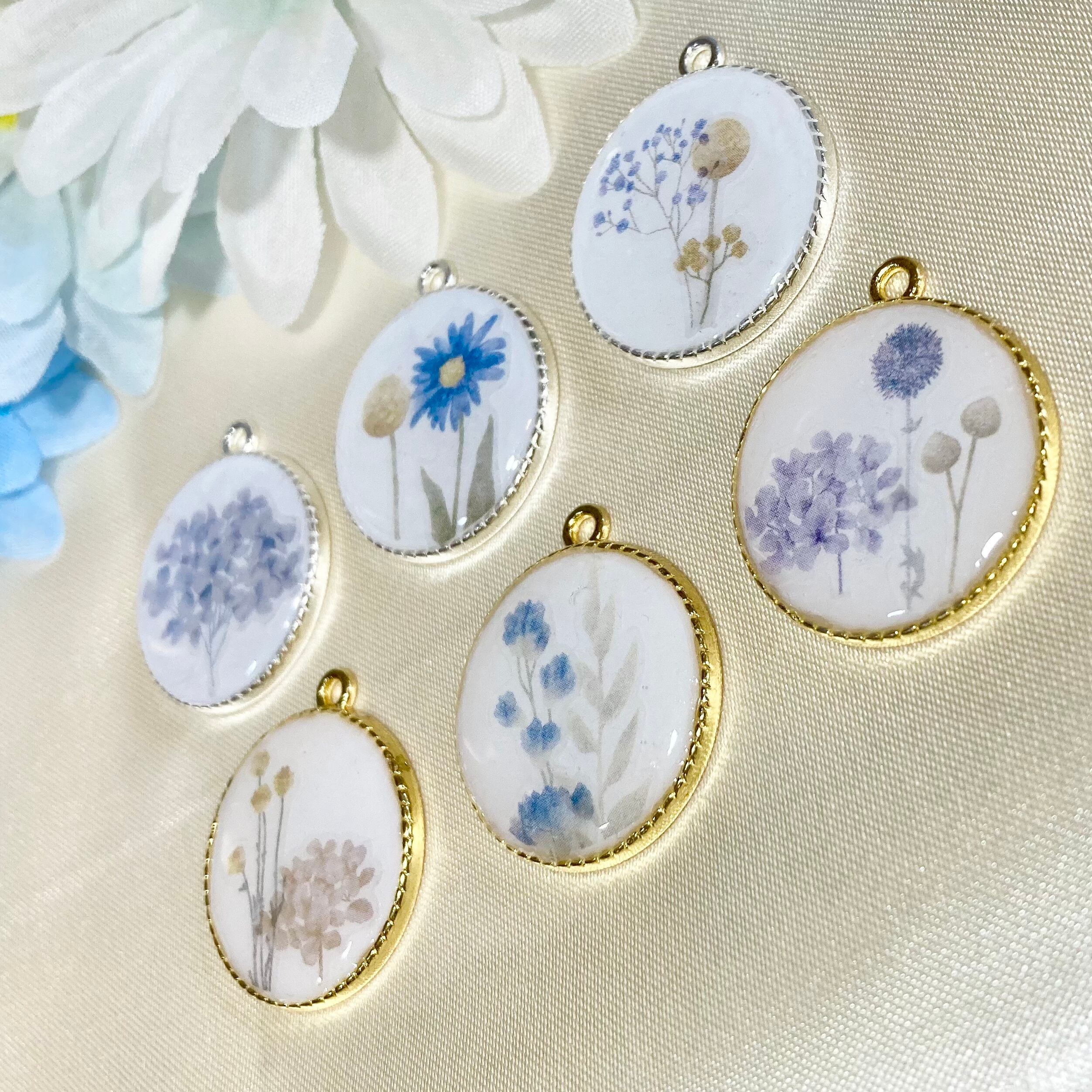 花が描かれた白くて丸いペンダントトップ シックな雰囲気のレジン