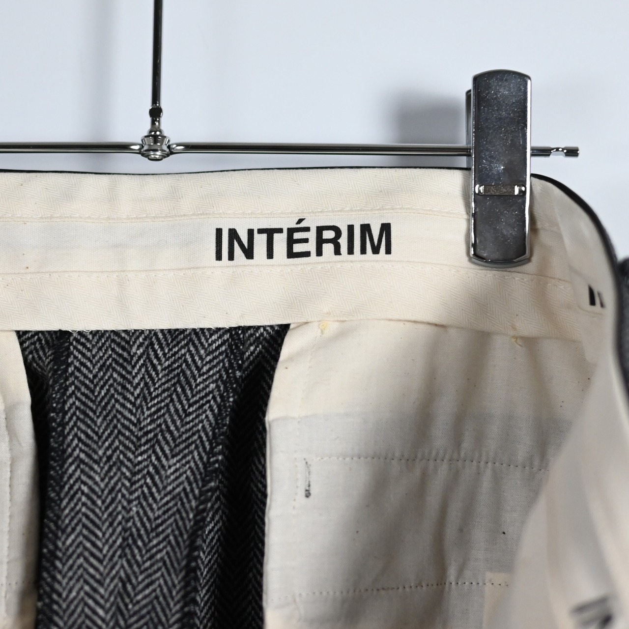 INTERIM / INDIA WOOL CLASSIC HERRINGBONE WITH LEATHER PIPING 2-TUCK STRAIGHT SLACKS