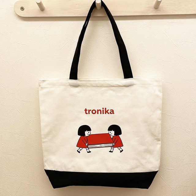 トートバッグ「トロニカ　双子イラスト　大きい本を運ぶ　白　持ち手黒　底黒」 - メイン画像