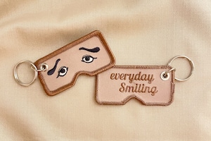 『Keep on Smiling』 にわかせんぺい × enricheveryday スティッチワーク キーホルダー／keep on Smiling にわか面型ステッカー付