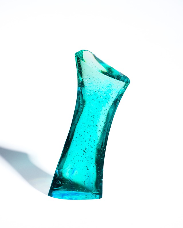 A streamlined, turquoise-blue glass object