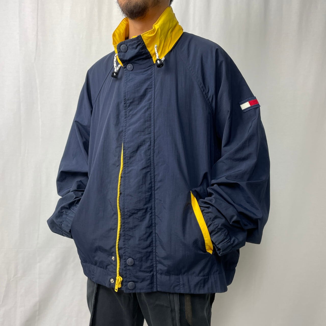 90年代 TOMMY HILFIGER トミーヒルフィガー ナイロンセーリングジャケット メンズXL相当 古着 90s ヴィンテージ ビンテージ  フード収納型 ハイネック ロゴ刺繍 ネイビー イエロー 紺色 黄色【ナイロンジャケット】 | cave 古着屋【公式】古着通販サイト