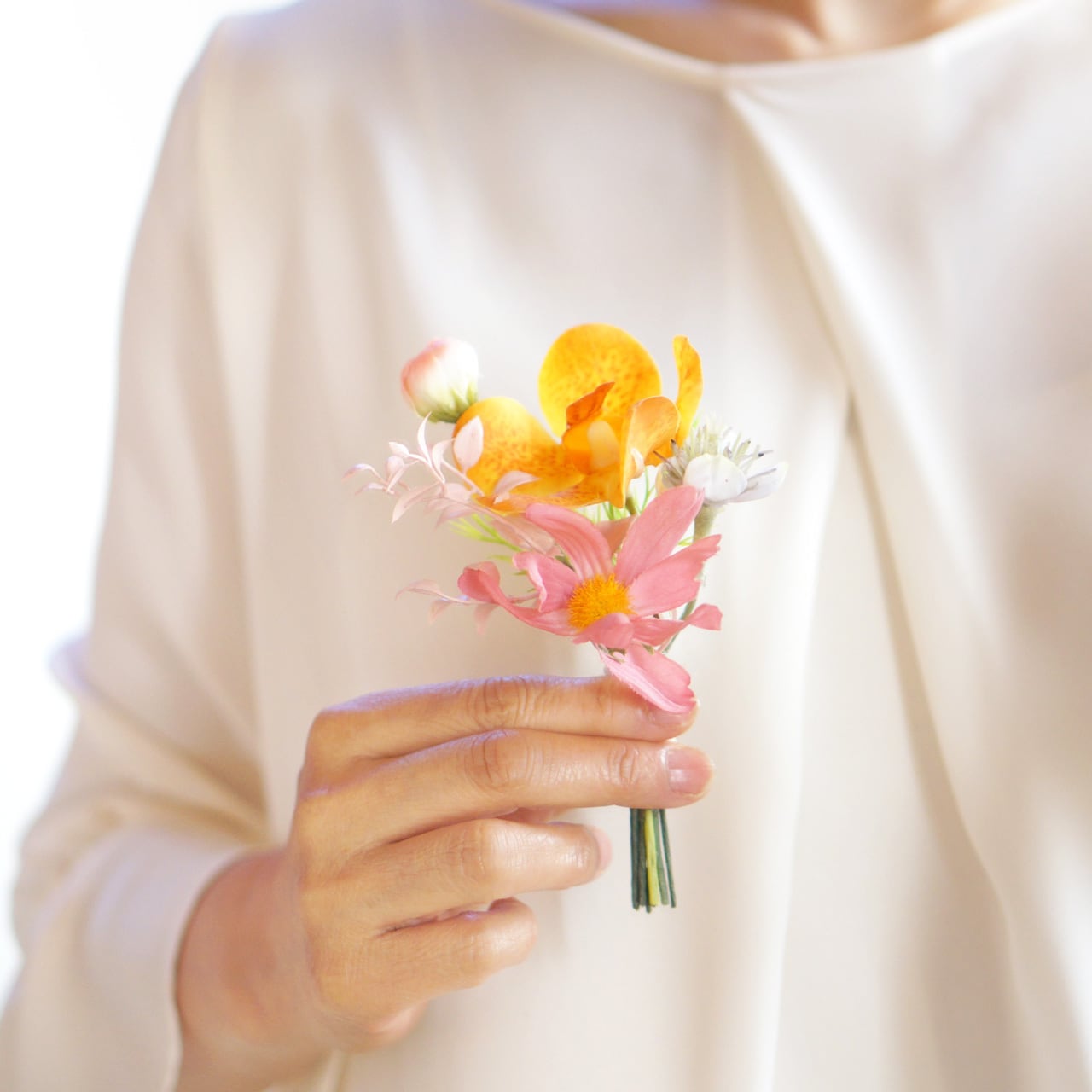 オレンジ色ランとピーチ色スイートピーの エアリーな春色ウェディング