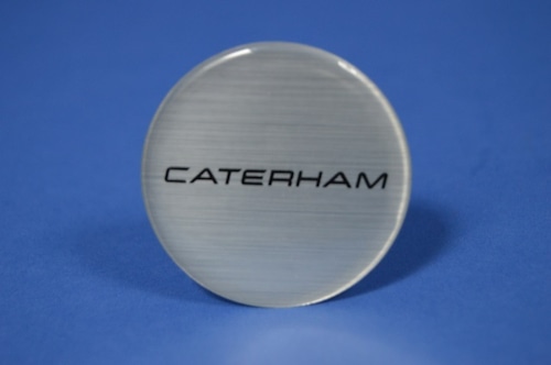 30W025A バッジ、ホイールセンターキャップ、CAETERHAM、ブラッシュドクローム、50mm 径、15"ホイール用、2013年式以降