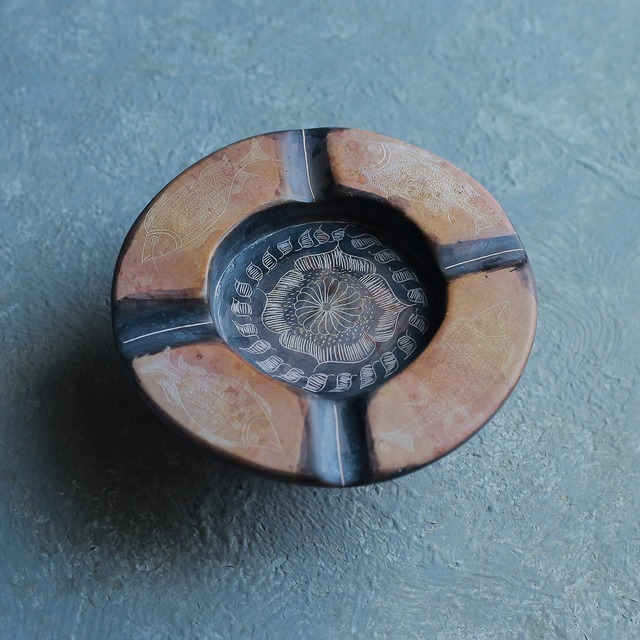 プリミティブな模様の、石で作られた灰皿