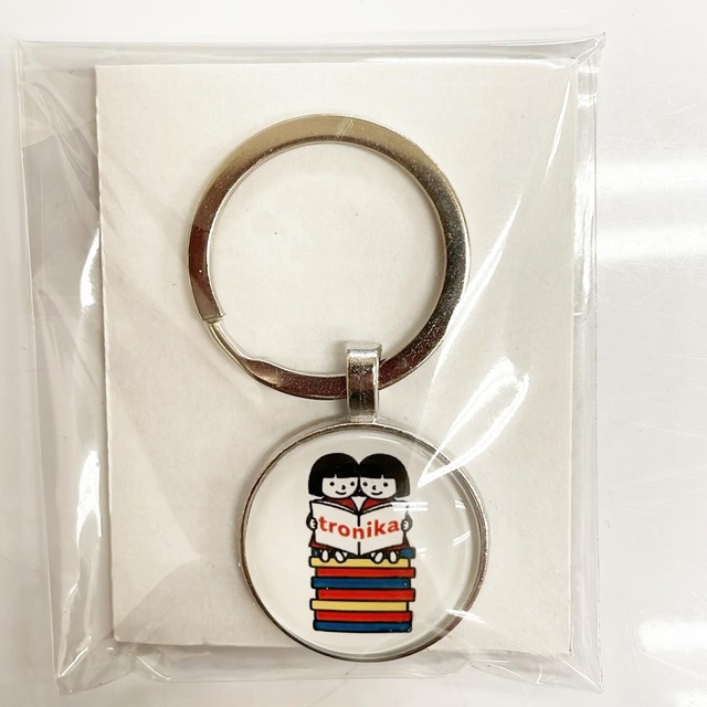 キーホルダー「トロニカ　双子　イラスト　2人で座って本を読む」 - メイン画像
