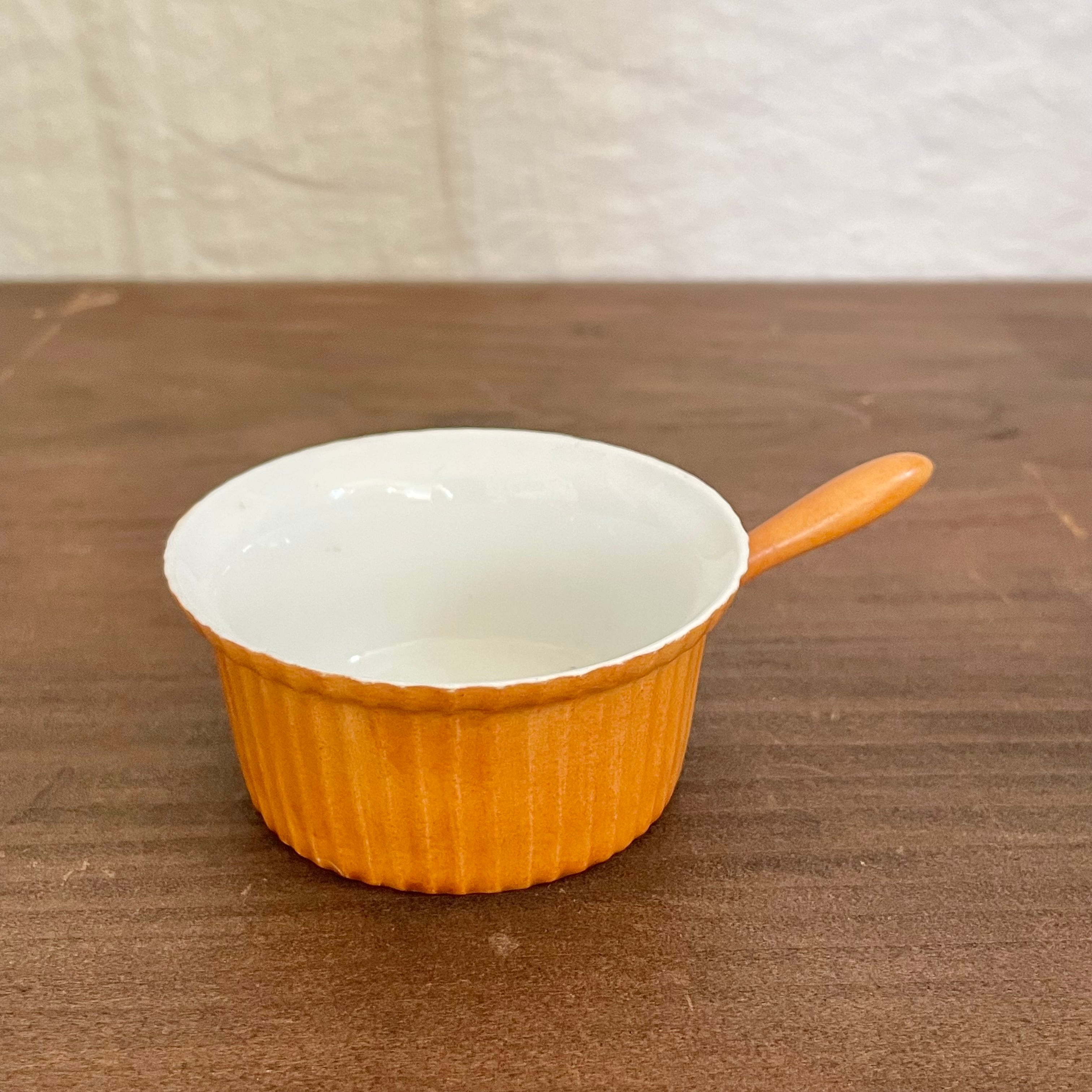 取っ手付きのオレンジ色の器