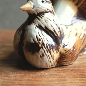 立派な尾っぽを見せる、味わい深い陶器の鳥