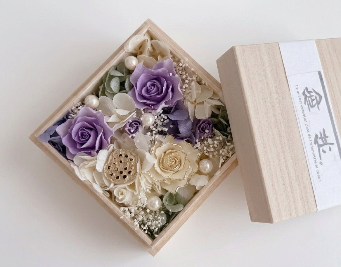 深みのあるグラデーションと洗練された白の薔薇が、お供えにふさわしい静かな気品を醸し出します。上質な桐箱を開けた瞬間に広がる凛とした佇まいは、大切な方への変わらぬ想いを伝えます。