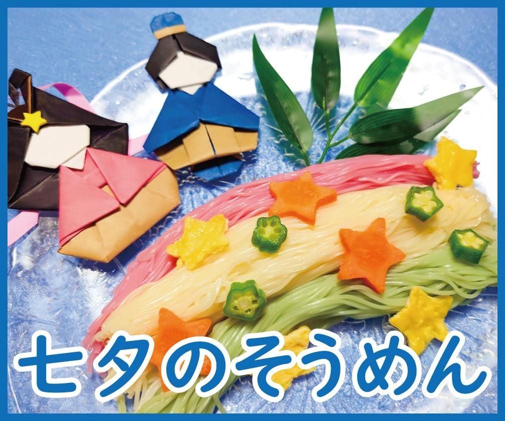 折り紙の織姫と彦星や笹の葉とともに、色とりどりのそうめんを天の川に見立てて盛り付け、星形の野菜をのせた一皿と「七夕のそうめん」の文字