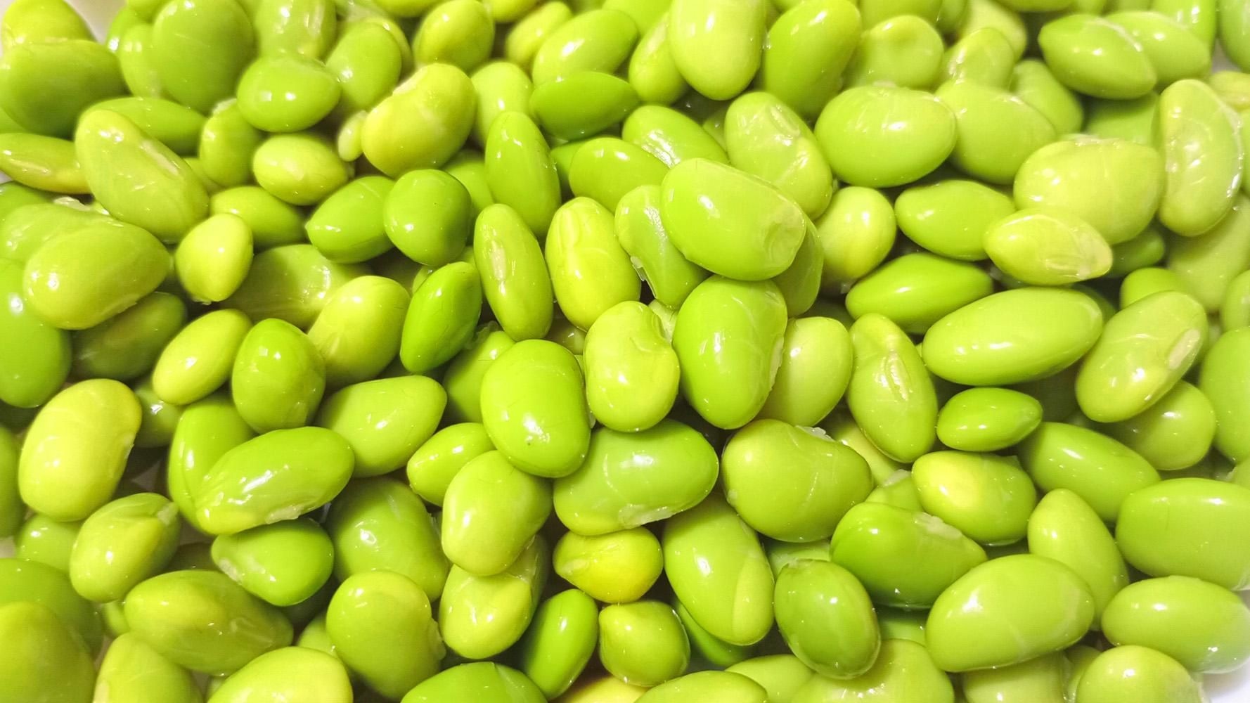 さやから取り出した、あざやかな緑色の枝豆の豆のアップ