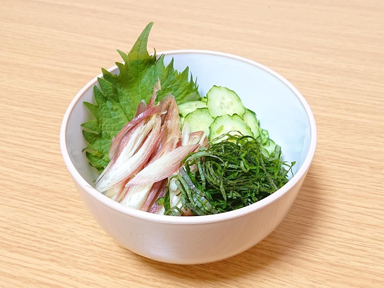 白い器に盛った薬味。大葉（青じそ）の葉と千切り、薄切りのみょうが、きゅうり